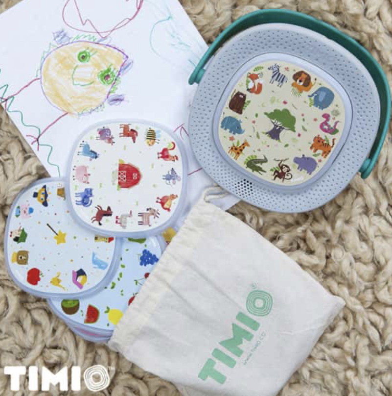 Timio toy and discs laied on carpet next to a child's drawing