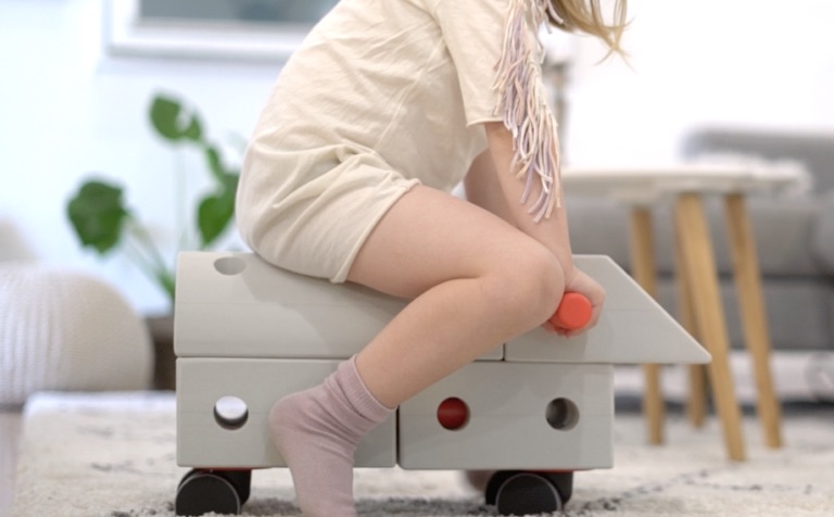 Young girl riding on MODU toy
