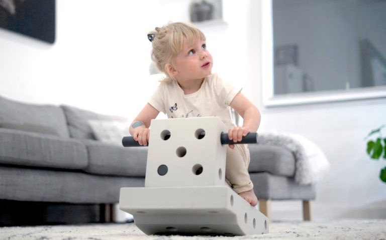 Young girl riding on MODU toy and looking up to the right